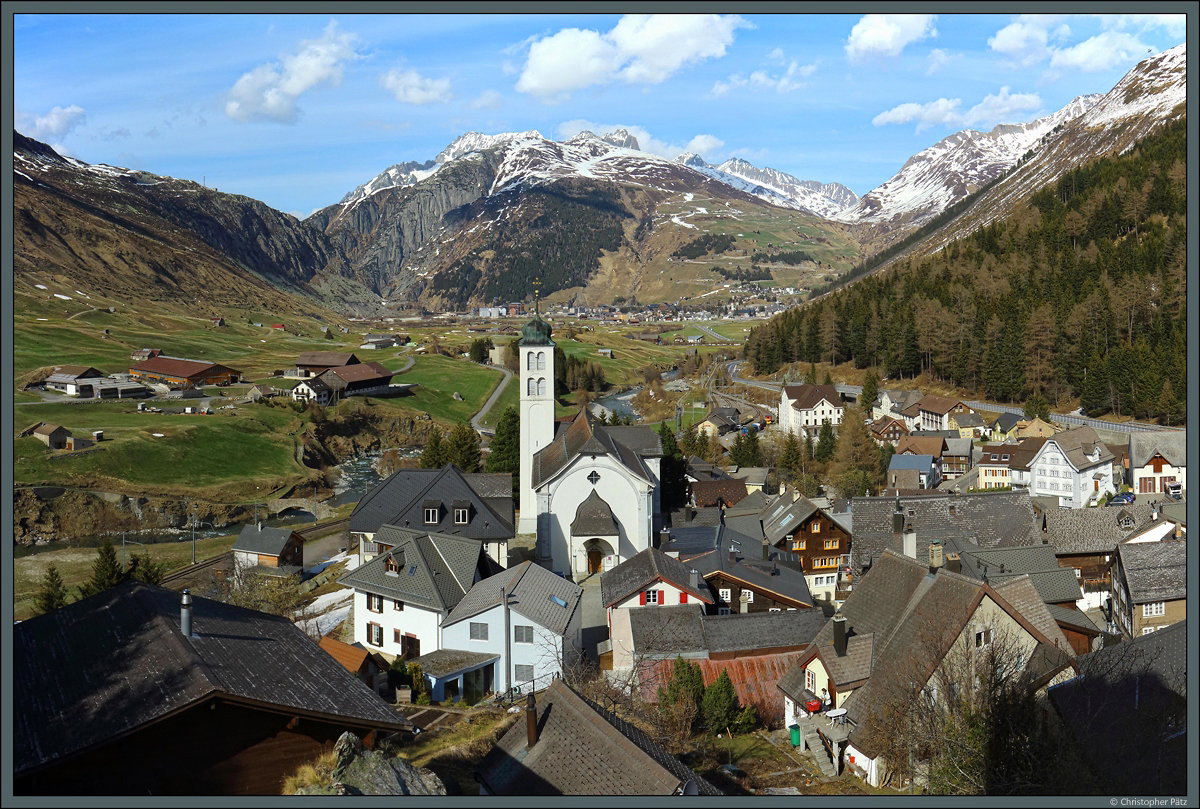 Blick von der Turm der Herren von Hospental auf den gleichnahmigen Ort und dessen Pfarrkirche. Vor dem Berg Ntschen liegt im Hintergrund der Skiort Andermatt. (19.04.2022)