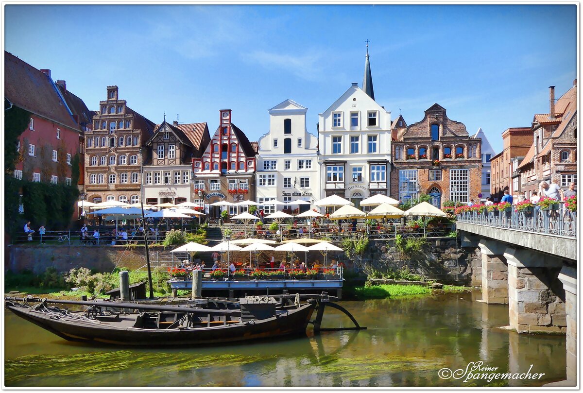 Blick ber die Ilmenau in Lneburg. Ein warmer und sonniger Sptsommertag, die Besucher relaxen in den zahlreichen Straencafs. Anfang September 2023 