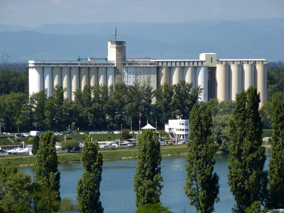 Breisach, Teleblick vom Burgberg ber den Rhein, die Grosilos gehren zum Rheinhafen von Neubreisach/Colmar, im Hintergrund die Vogesen, Aug.2015