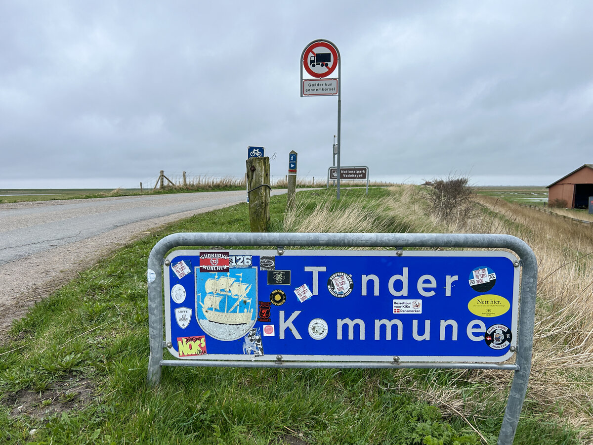 Das Gemeindeschild ist am Eingang der Gemeinde Tnder (Tondern) in Siltoft nahe der dnisch-deutschen Grenze mit Aufklebern versehen. Aufnahme: 2. April 2024.