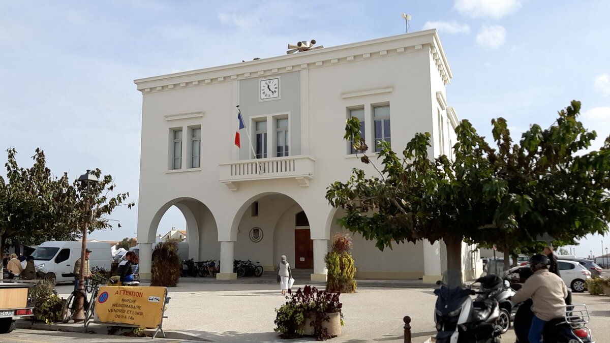 Das Hotel de Ville, das Rathaus von Saintes-Maries-de-la-Mer am 16.10.2023. Der Ort, meist kurz nur Saintes-Maries genannt, gilt als heimliche „Hauptstadt“ der Camargue. Saintes-Maries ist nmlich ein internationaler Wallfahrtsort, zu dem jedes Jahr Tausende von Glubigen pilgern. Vor allem die Wallfahrt am 24. und 25. Mai lockt Jahr fr Jahr viele Roma aus der ganzen Welt an, die die Schreine der heiligen Maria Jakoba und der heiligen Maria Salome verehren.