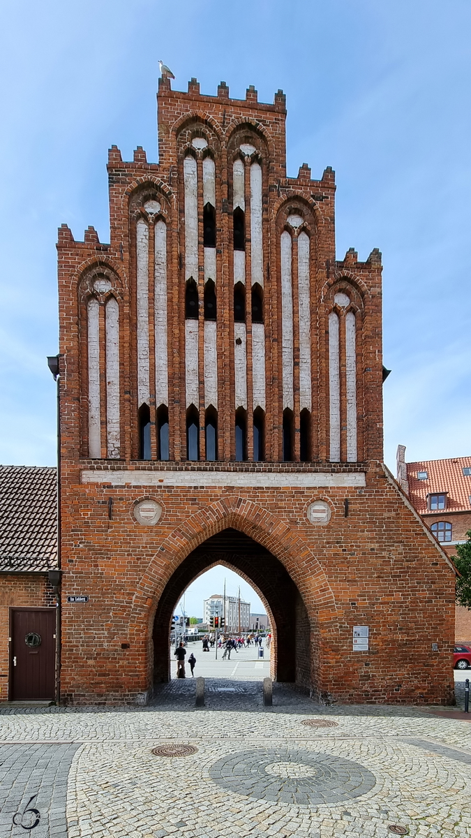 Das um 1450 im Stil der Backsteingotik erbaute Wassertor ist das letzte erhaltene von ursprnglich fnf Stadttoren in Wismar. (Mai 2023)