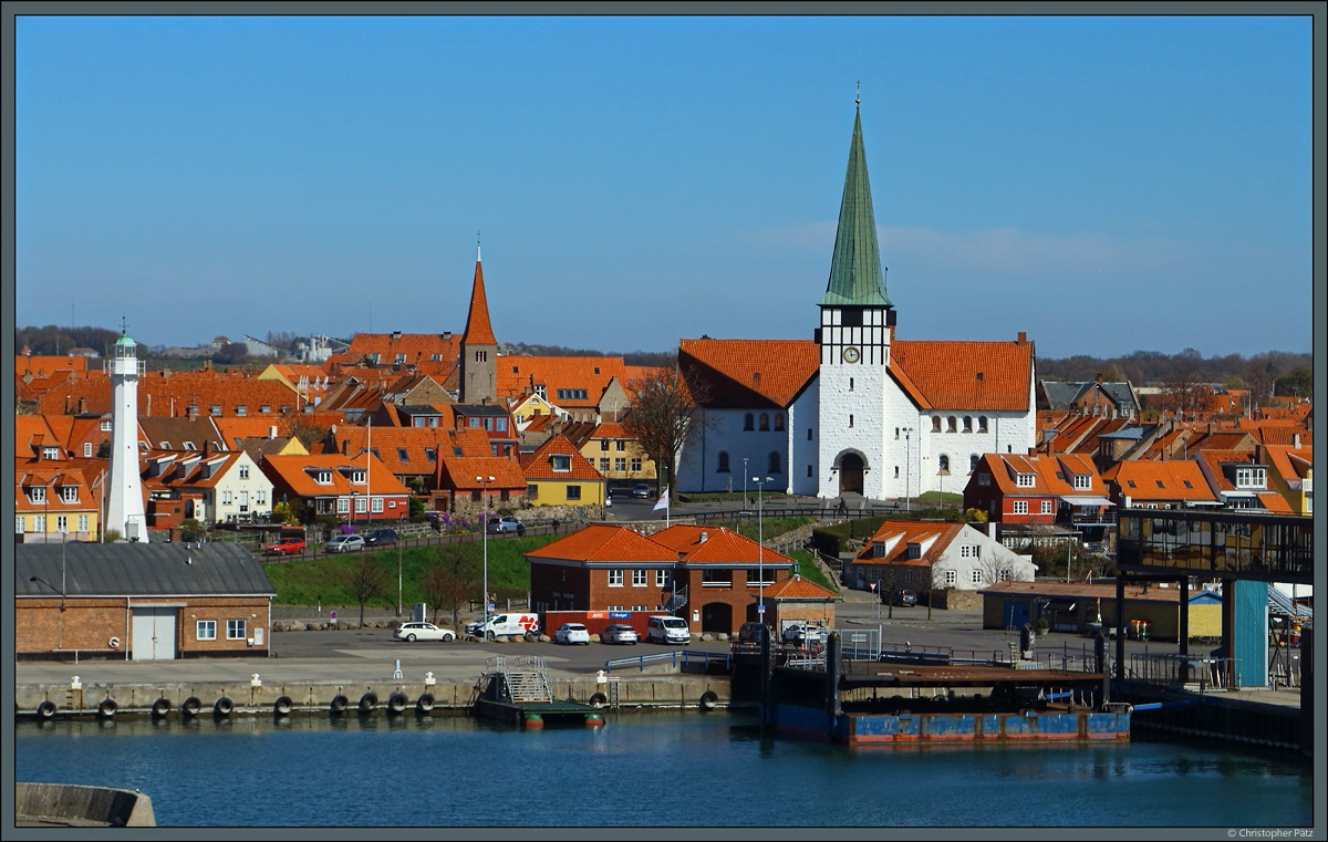 Das Zentrum von Rnne mit dem Leuchtturm, der Methodistischen Kirche und der weien Kirche Sankt Nicolai. (22.04.2019)