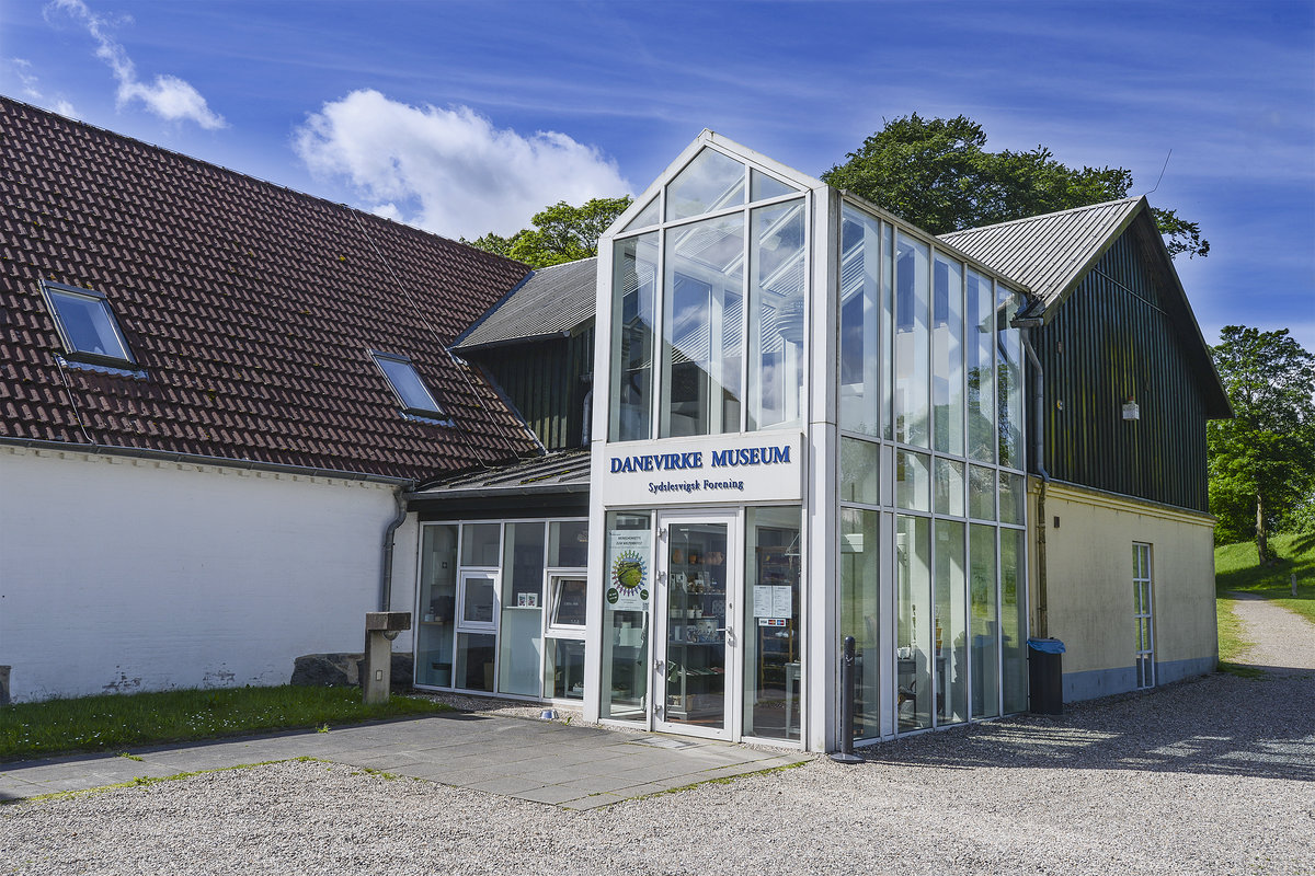 Der Eingang zum Danevirke Museum in Dannewerk westlich von Schleswig. Das Museum liegt unmittelbar am Hauptwall des Danewerks und in kurzem Abstand zu den wichtigsten Bauwerken in der Geschichte dieser frhmittelalterlichen Befestigungsanlage.
Das Museum enthlt eine stndige Ausstellung zum Danewerk, das heute Weltkulturerbe ist. Darber hinaus wird in zwei weiteren Ausstellungen die Bedeutung des Danewerks im deutsch-dnischen Krieg von 1864 sowie die Geschichte der dnischen Minderheit von 1864 bis in die Gegenwart dokumentiert.
Aufnahme: 27. Mai 2019.