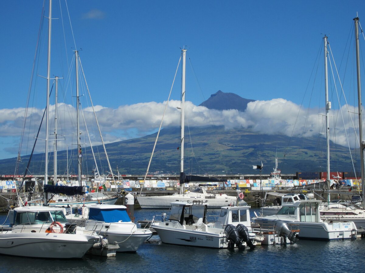 Der Jachthafen von Horta auf der Azoren-Insel Faial ist eine beliebte Zwischenstation für Skipper bei Atlantiküberquerungen. Im Hintergrund der Vulkan Pico. Aufnahme vom 26.07.2023.