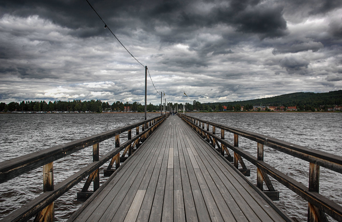 Die Lngbrygga (lange Brcke) in Rttvik (Dalarna / Schweden) ist 628 Meter lang. Von 1895 an machte hier fast sechzig Jahre lang der Dampfer S/S Rttvik fest. Mit den Jahren jedoch war die Seebrcke durch Wind, Wetter und die Krfte des Eises zerstrt. Am 6. Juni 1992, am schwedischen Nationalfeiertag, wurde die Brcke nach einer Totalrenovierung wieder eingeweiht.
Aufnahme: 31. Juli 2017.