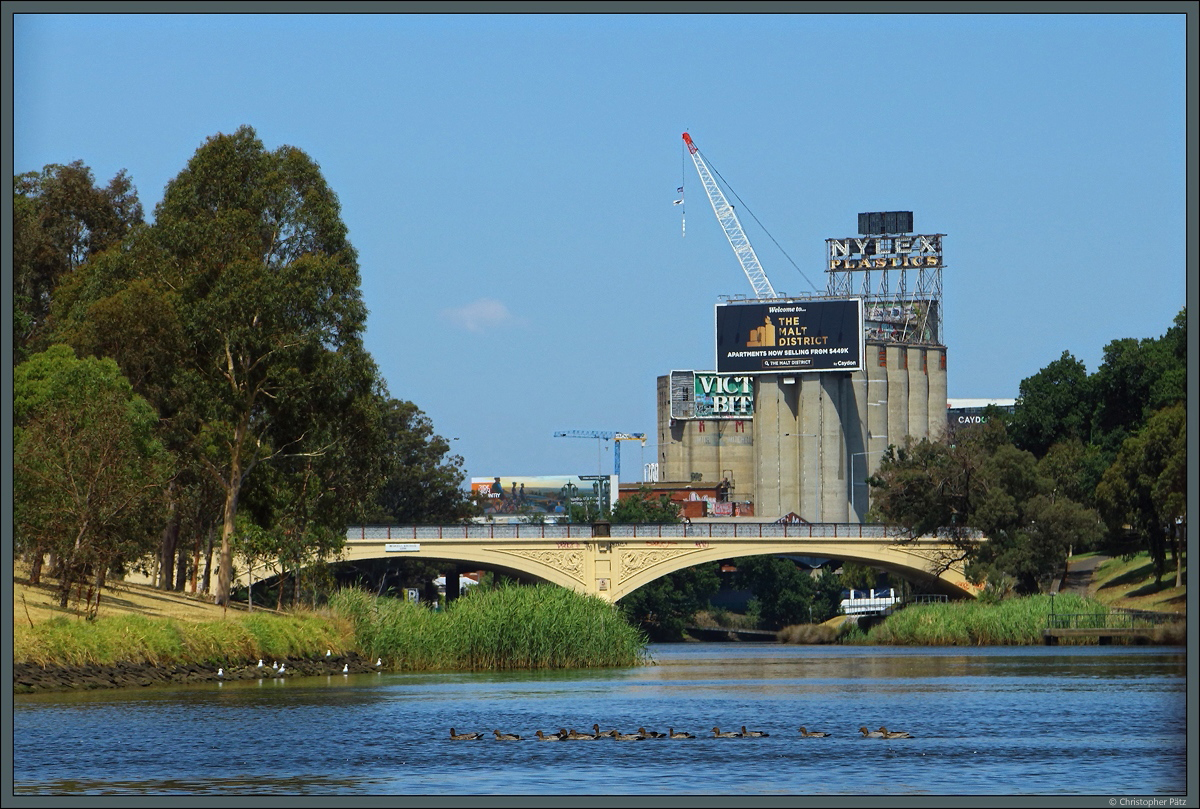 Die 1899 erbaute Morell Bridge berspannt den Yarra River im Zentrum von Melbourne. Im Hintergrund die ehemaligen Malz-Silos mit alter Leuchtreklame. (29.12.2019)