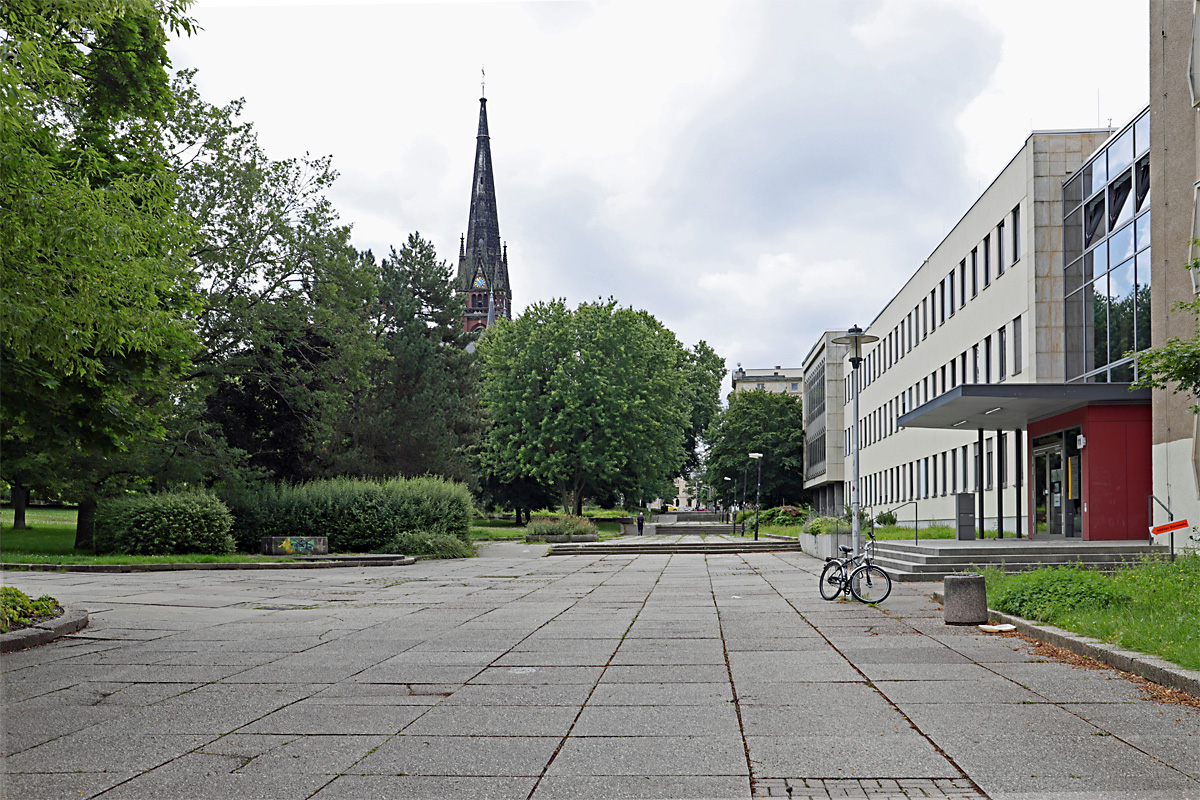 Die Amthorstrae in Gera mit Blick in Richtung Clara-Zetkin-Strae, der Turm gehrt zur Kirche St. Johannis, aufgenommen am 04.08.2021. Das Gebude rechts beherbergte vor 1990 die
Bezirksleitung der SED, danach waren verschiedene Firmen und auch das Kreisgericht darin untergebracht. Auf dem bunt bemalten Sockel in der linken Hlfte sa der Genosse Lenin, der inzwischen einen neuen Platz im Stadtteil Unterhaum gefunden hat.