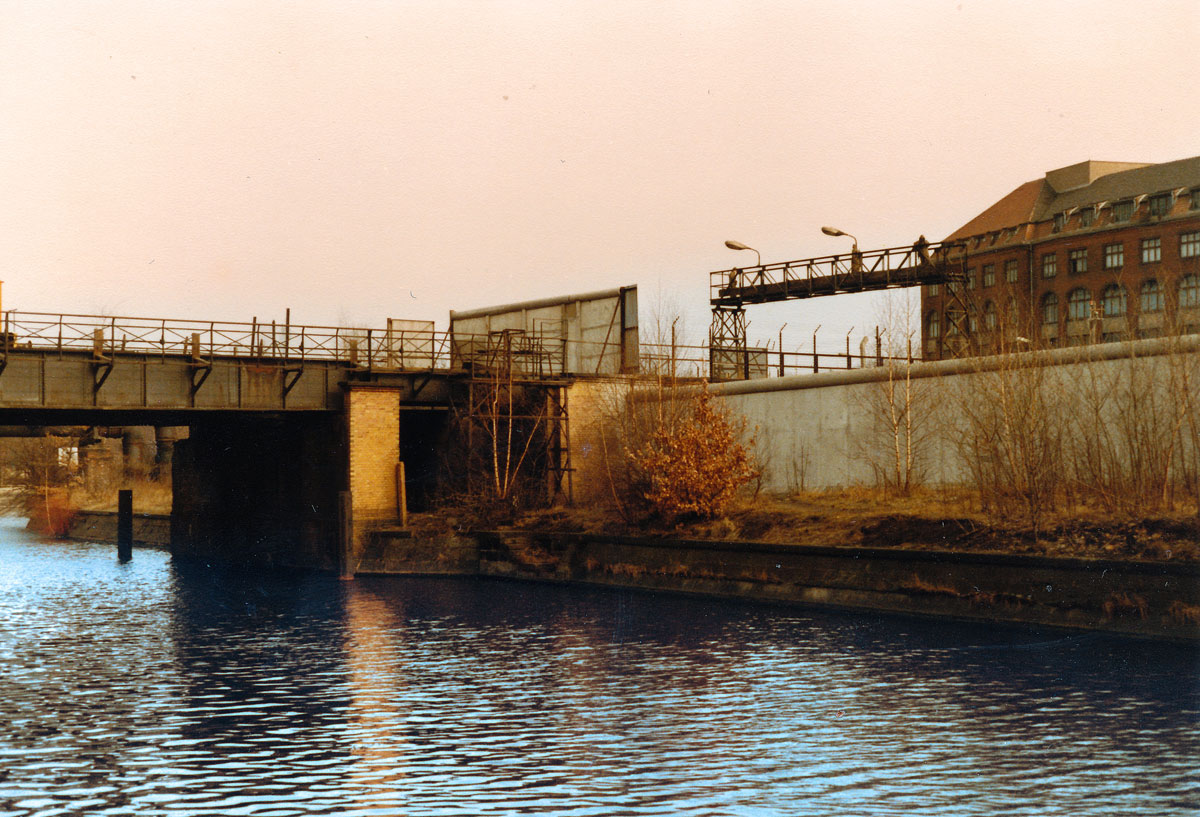 Die Berliner Mauer am Landwehrkanal (Brücke Schlesische Straße-Puschkinallee). Aufnahme: März 1984 (digitalisiertes Negativfoto).