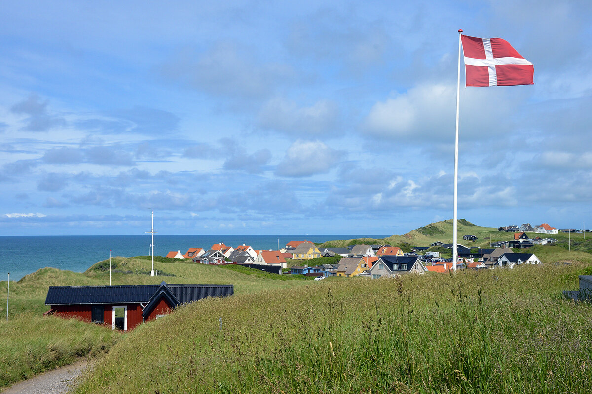 Die d�nische Flagge �Dannebrog� mit dem nordj�tl�ndischen Badeort L�nstrup im Hintergrund. Aufnahme: 13. Juni 2026.