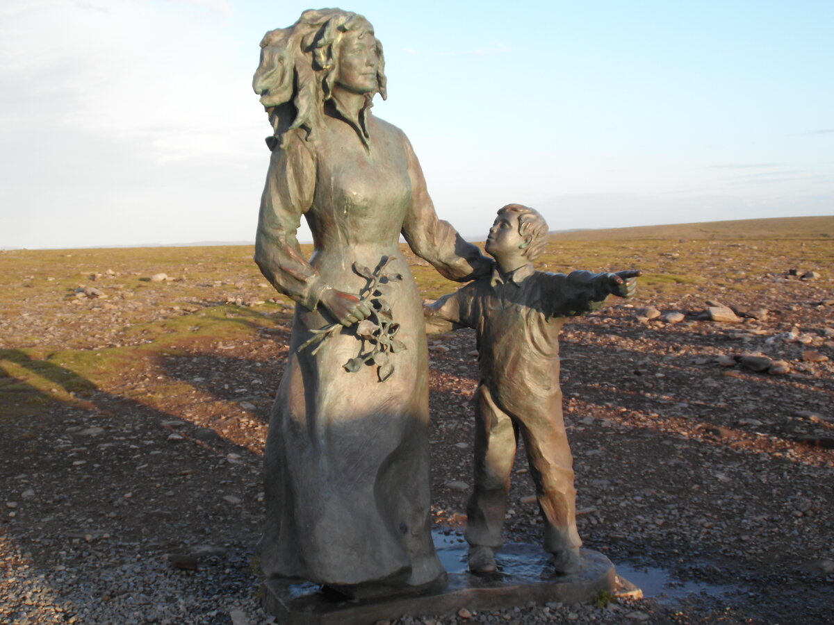 Die Figurengruppe  Das Denkmal der Kinder der Welt , ist ein Denkmal auf dem Nordkapplateau in Norwegen . Es befindet sich sdstlich der Nordkaphalle und besteht aus sieben groen kreisrunden Reliefs, die stehend im Halbkreis angeordnet sind. Das Bild zeigt einen Teil der Figurengruppe, die von der Knstlerin Eva Rybakken geschaffen wurde. 07.07.13 (kurz vor Mitternacht).
Der Horizont ist nicht schief, das Gelnde steigt nach rechts an !