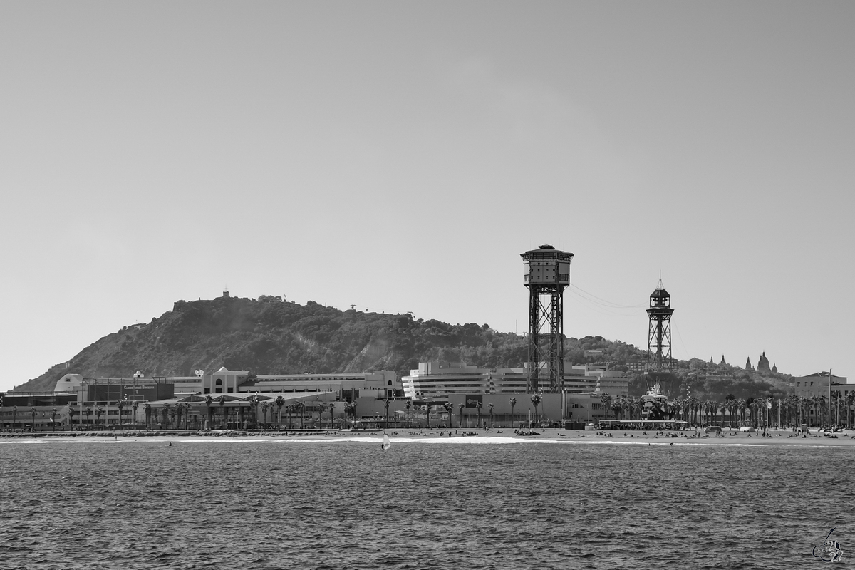 Die Hafenseilbahn in Barcelona (Teleférico del puerto Barcelona) sollte eine der Attraktionen der Weltausstellung im Jahr 1929 werden, konnte jedoch erst 1931 eröffnet werden, im Hintergrund zu sehen der 173 Meter hohe Berg Montjuïc. (November 2022)