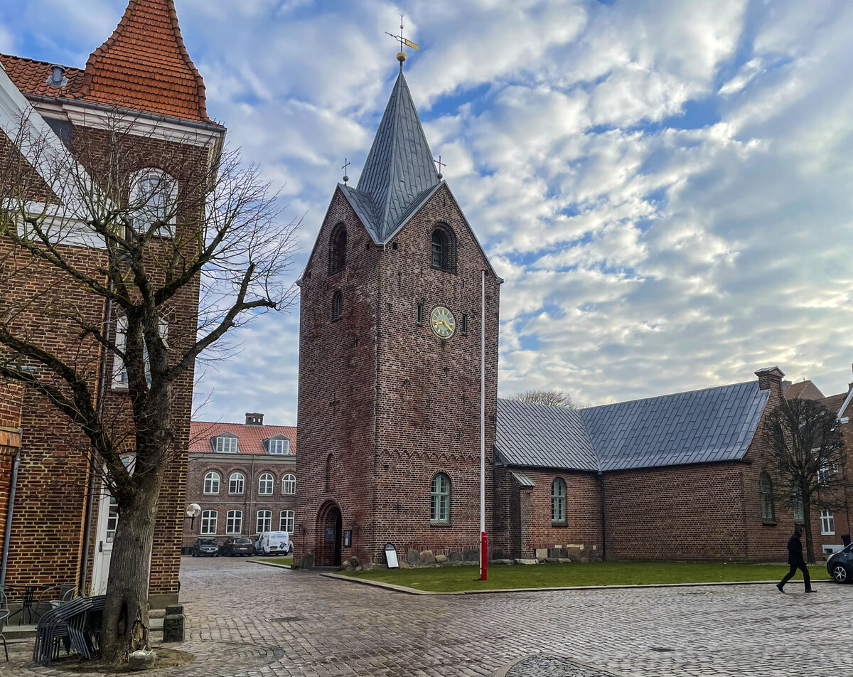 Die Kirche in Ringkbning stammt aus der ersten Hlfte des 15. Jh., wurde allerdings mehrmals erweitert. Das Mauerwerk der Kirche besteht aus Backstein, war jedoch in mehr als 100 Jahren gekalkt. Der Turm wurde kurz nach der Reformation ca. 1550 errichtet. Aufnahme: 25. Mrz 2022