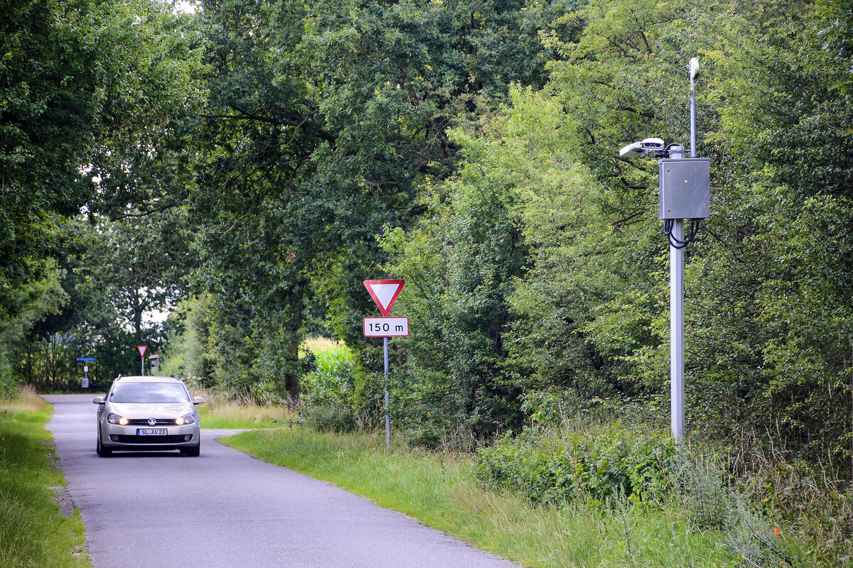 Die Kraftfahrzeugkennzeichen von Autos werden automatisch gescannt, wenn sie die dnisch-deutsche Grenze passieren. Hier befinden wir ins am dnischen Kristianmindevej zwischen dem deutschen Wilmkjerweg und der Frslev Plantage (Frsleer Wald). Aufnahme: 28. Juli 2023.