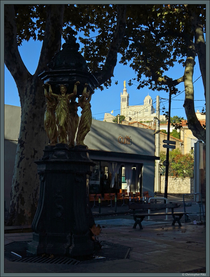 Die kunstvoll gestalteten Wallace-Brunnen spenden frisches Trinkwasser. Auch in Marseille gibt es ein paar dieser Brunnen. Im Hintergrund ist die Kirche Notre-Dame-de-la-Garde zu sehen. (Marseille, 29.09.2018)
