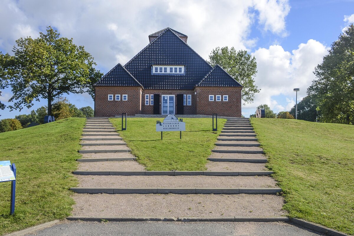 Die Neulandhalle ist ein in den Jahren 1935/1936 errichtetes Gebude im Dieksanderkoog, der Teil der Gemeinde Friedrichskoog im Kreis Dithmarschen, Schleswig-Holstein ist. Die Neulandhalle war seit der Grundsteinlegung durch Adolf Hitler am 29. August 1935 Bestandteil des nationalsozialistischen Propaganda. Diese stilisierte die Eindeichung des Dieksanderkoogs als Auftakt zur Realisierung des im Jahr 1933 vom Gauleiter und Oberprsidenten der Provinz Schleswig-Holstein in Preuen Hinrich Lohse prsentierten Generalplans fr die Landgewinnung Schleswig-Holstein hoch. Aufnahme: 21. September 2022.