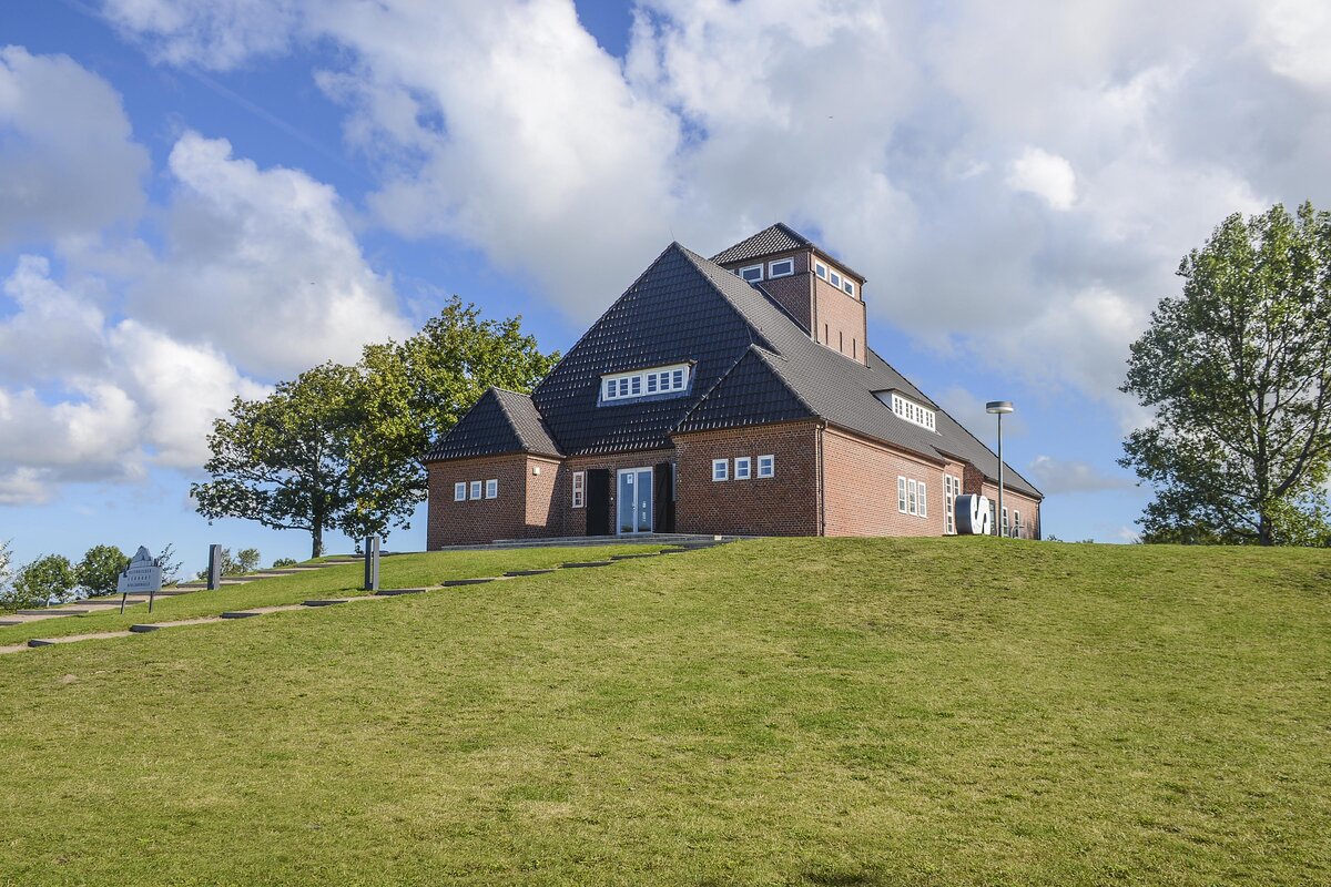 Die Neulandhalle im Kreis Dithmarschen wurde im Jahr 1935 gebaut – als zentraler Versammlungsort im gerade eingedeichten „Adolf-Hitler-Koog“ (heute: Dieksanderkoog). Mit viel Propaganda feierten sich hier Nationalsozialisten fr eine „friedliche Erweiterung deutschen Lebensraums“ und die Errichtung einer „Volksgemeinschaft im Kleinen“. Diese Verheiungen erschienen damals attraktiv und erzeugten Zustimmung zur nationalsozialistischen Herrschaft.
Aufnahme: 22. September 2022.