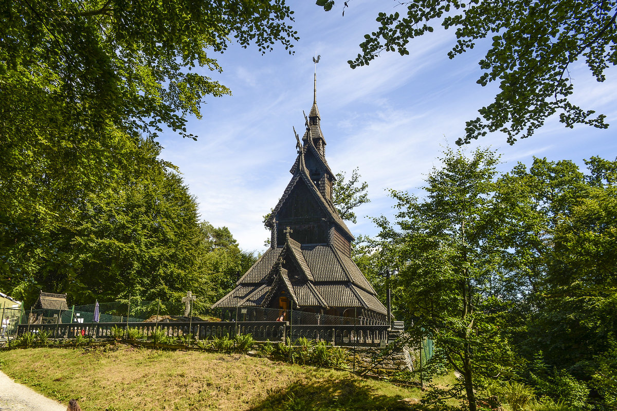 Die Stabkirche in Fantoft bei Bergen (Norwegen). Die Kirche brannte am 6. Juni 1992 nach einem Brandanschlag komplett nieder. Nur verkohltes Geblk und eine verbrannte Eingangstr zeugten von der ehemaligen Kirche. Varg Vikernes, Grnder des Black-Metal-Projektes Burzum, druckte eine Photographie der berreste auf das Cover der 1993 verffentlichten Burzum-EP Aske (norwegisch fr Asche), den ersten 1000 Exemplaren lag auerdem ein Feuerzeug mit dem gleichen Aufdruck bei. Trotz angeblich recht eindeutiger Indizien konnte Vikernes nicht verurteilt werden. 
Aufnahme: 11. Juli 2018.