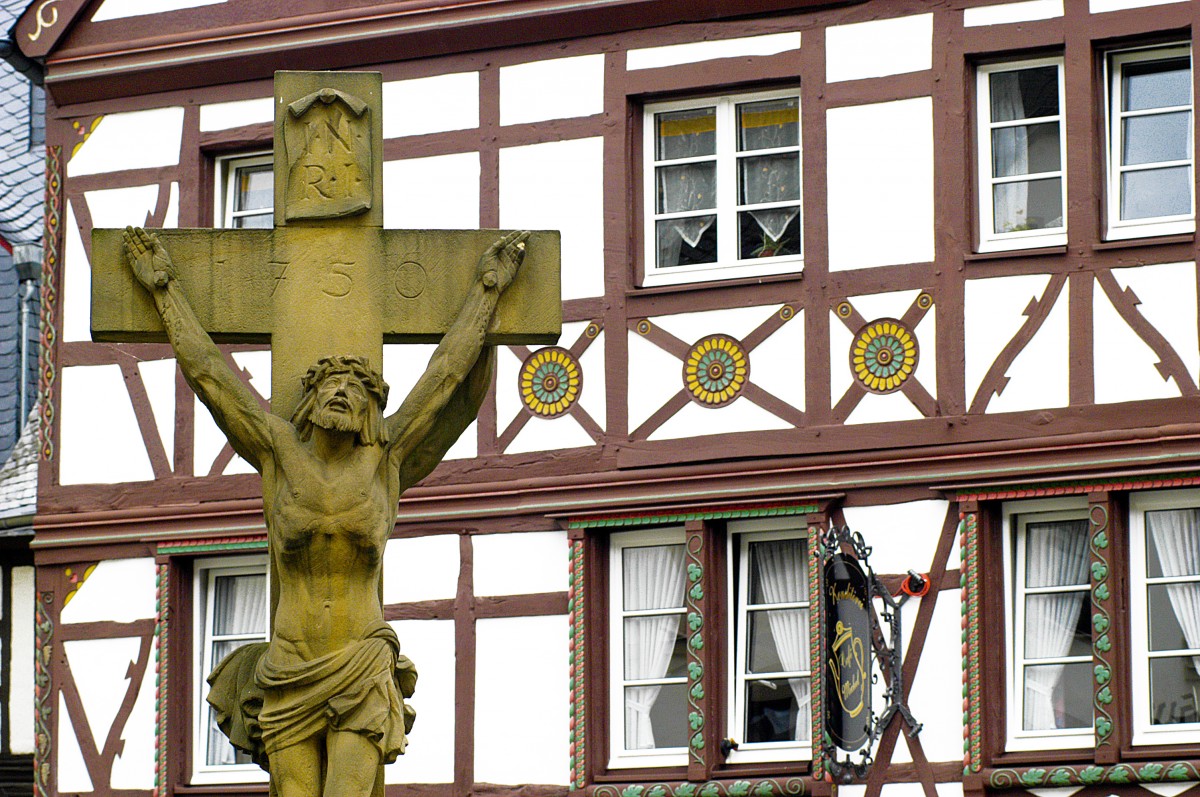 Doppel-Korpus-Kreuz mit Fachwerk im Hintergrund in der Rmerstrae in Bernkastel-Kues. Aufnahme: Juli 2007.