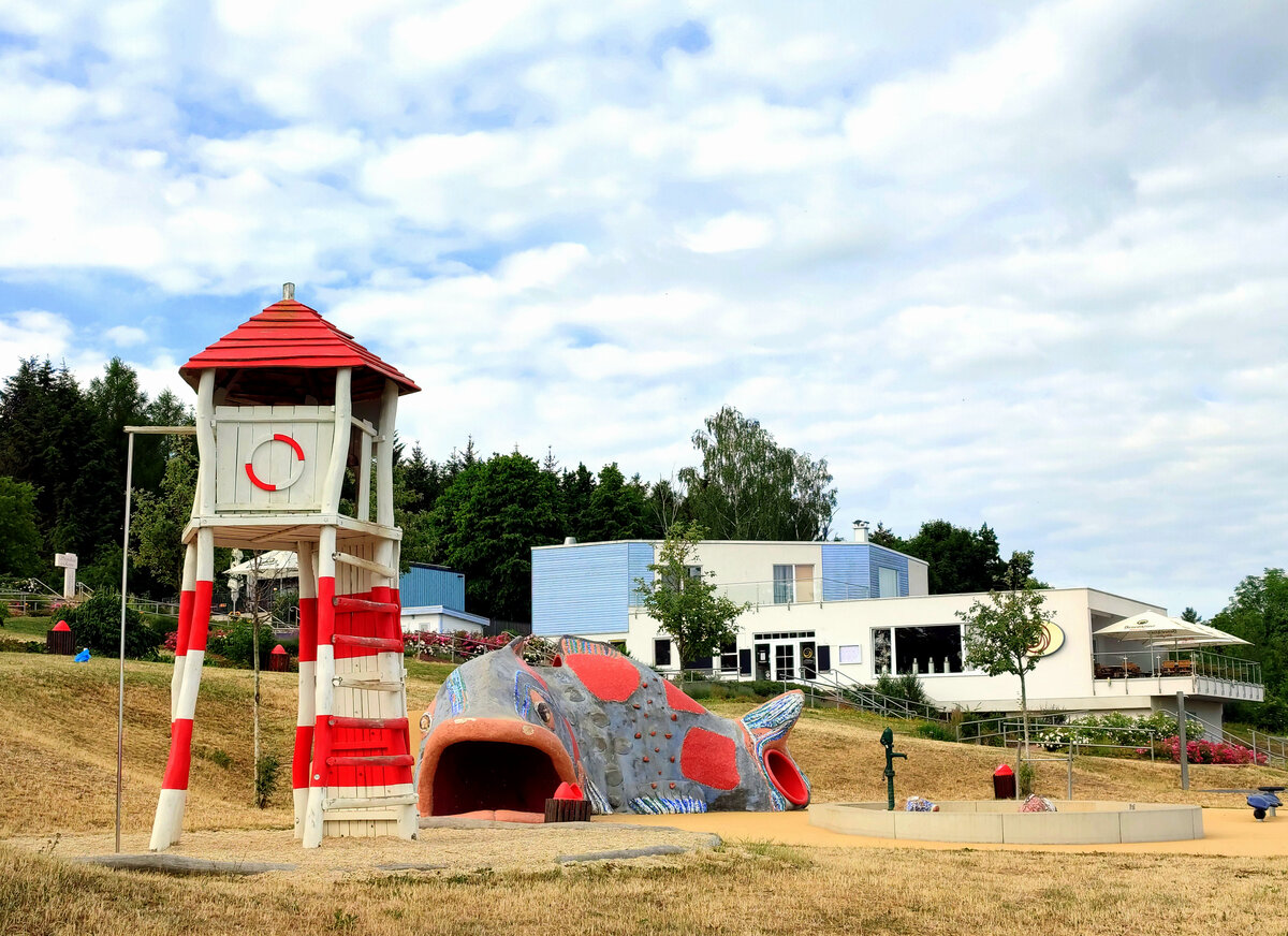 Ein Blick auf das Strandbad - Zeulenrodaer Meer. Kletterturm auf dem Spielplatz. Der Zugang zu allen Einrichtungen und zum Wasser ist komplett barrierefrei. Der schne Wiesenstrand ldt Gro und Klein zum Baden ein. Das Strandbad Zeulenroda ist durch den 3 km langen und barrierefreien Promenadenweg mit dem Bio-Seehotel Zeulenroda verbunden.Foto 22.06.22