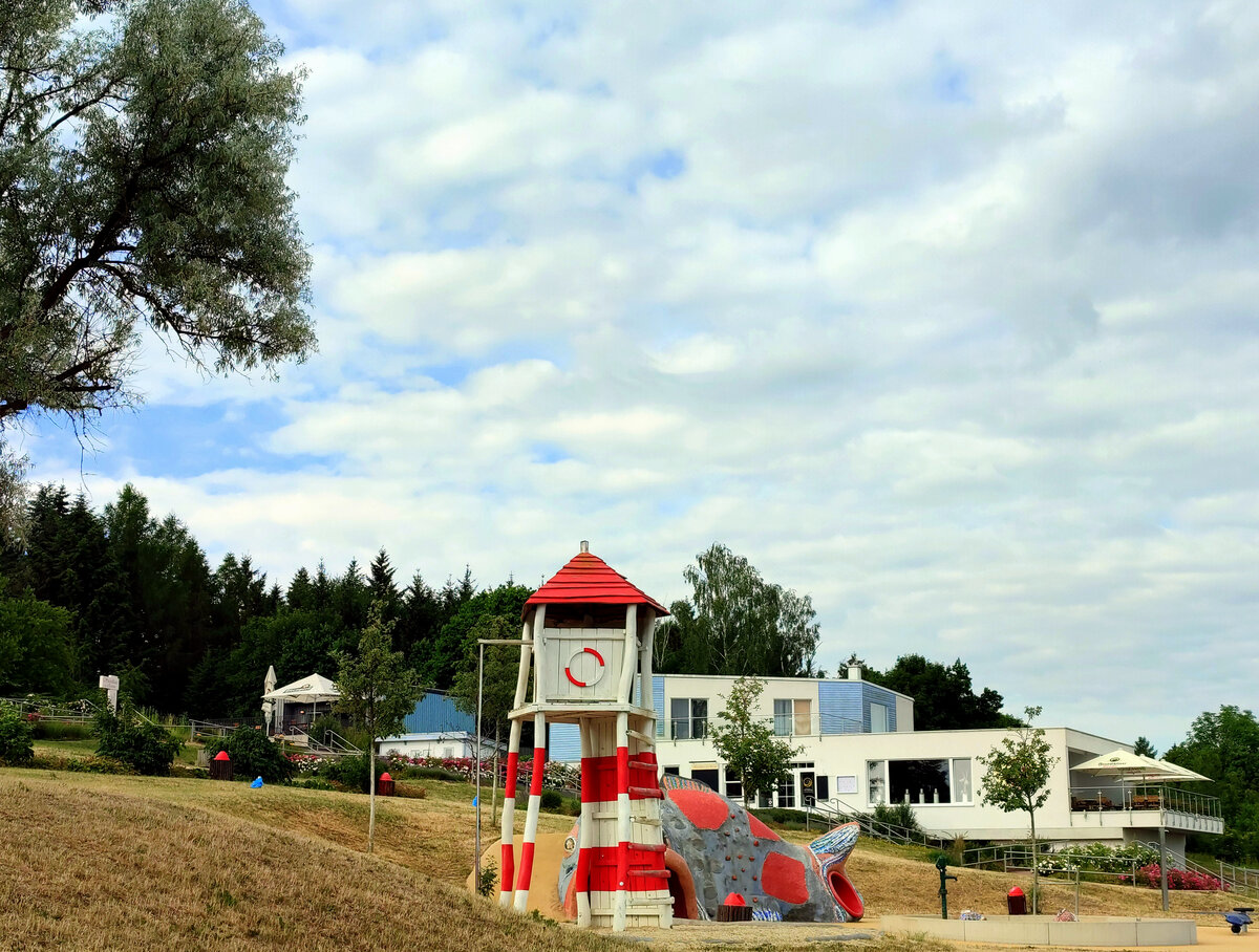 Ein Blick auf das Strandbad - Zeulenrodaer Meer. Kletterturm auf dem Spielplatz. Der Zugang zu allen Einrichtungen und zum Wasser ist komplett barrierefrei. Der schne Wiesenstrand ldt Gro und Klein zum Baden ein. Das Strandbad Zeulenroda ist durch den 3 km langen und barrierefreien Promenadenweg mit dem Bio-Seehotel Zeulenroda verbunden.Foto 22.06.22