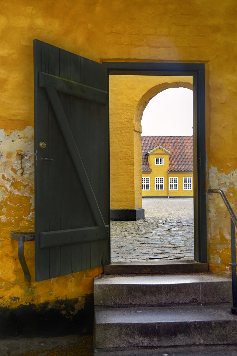 Ein Blick durch die Tr zum Innenhof vor dem Museum fr zeitgenssische Kunst in Roskilde. Aufnahme: 20. Juni 2023.