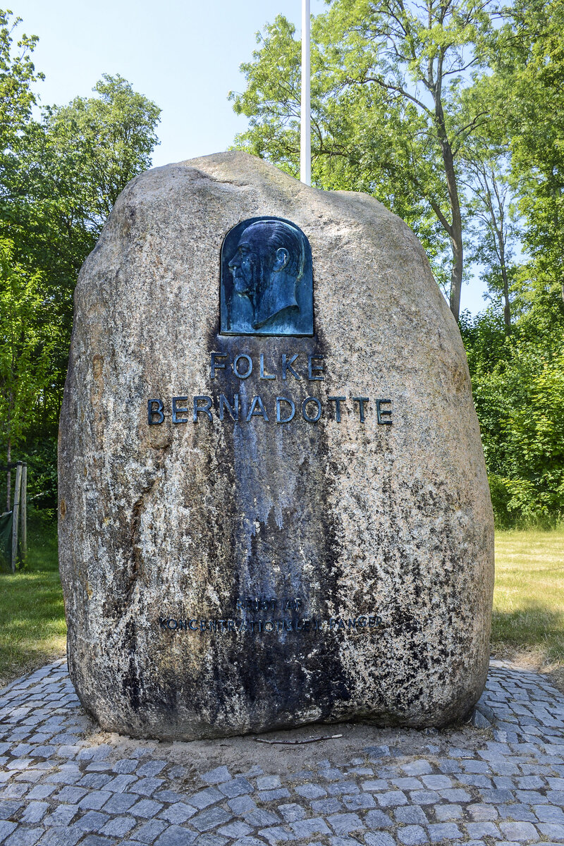 Ein Gedenkstein zu Ehren des schwedischen Grafen Folke Bernadotte. Am 1. September 1943 wurde er Vizeprsident des Schwedischen Roten Kreuzes. Im April 1945 erhielt er von Heinrich Himmler ein Waffenstillstandsangebot zur Beendigung des Zweiten Weltkriegs an die USA und das Vereinigte Knigreich, das ber Stockholm nach London und Washington bermittelt, von dort aber abgelehnt wurde.

Des Weiteren verhandelte Bernadotte in seiner Funktion im Jahr 1945 mit Heinrich Himmler erfolgreich ber die Zusammenfhrung und Freilassung der skandinavischen KZ-Hftlinge. Zustzlich zu ca. 8.000 Hftlingen skandinavischer Herkunft wurden im Rahmen dieser Mission etwa 10.000 bis 12.000 Hftlinge anderer Nationalitt vor allem aus Ravensbrck und Theresienstadt zunchst im Lager Neuengamme bei Hamburg gesammelt und spter nach Schweden berfhrt. Durchgefhrt wurde diese Aktion, die in die schwedische Geschichte und die Geschichte der Rotkreuz-Bewegung als die „Weien Busse“ eingegangen ist, kurz vor Kriegsende von ca. 250 Helfern des Schwedischen Roten Kreuzes.

Aufnahme: 11. Juni 2023.