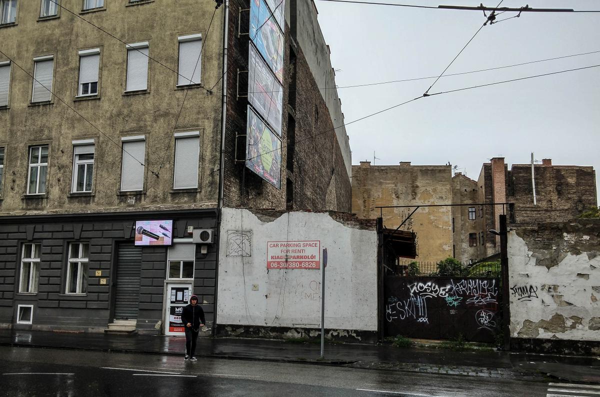 Ein Haus und ein leeres Grundstck, das als Parkplatz funktioniert. Leider sind die wnde durch Graffitis verschmutzt, was ich schade finde. Budapest, 21.09.2017.