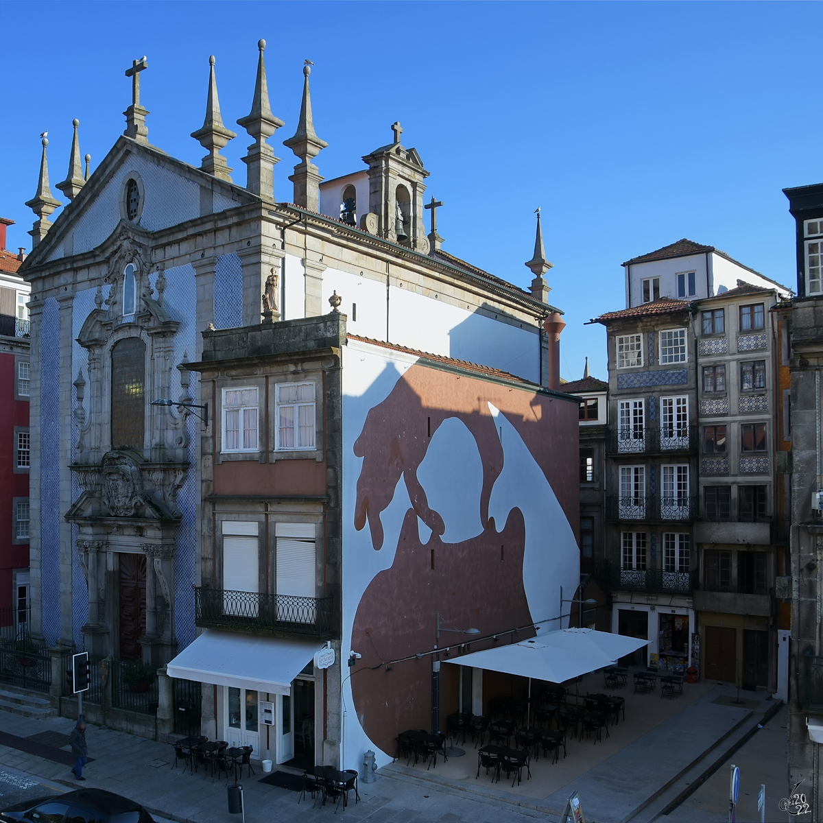 Ein kleines Restaurant, dahinter die St. Nicholas-Kirche (Igreja Paroquial de So Nicolau) in Porto. (Januar 2017)