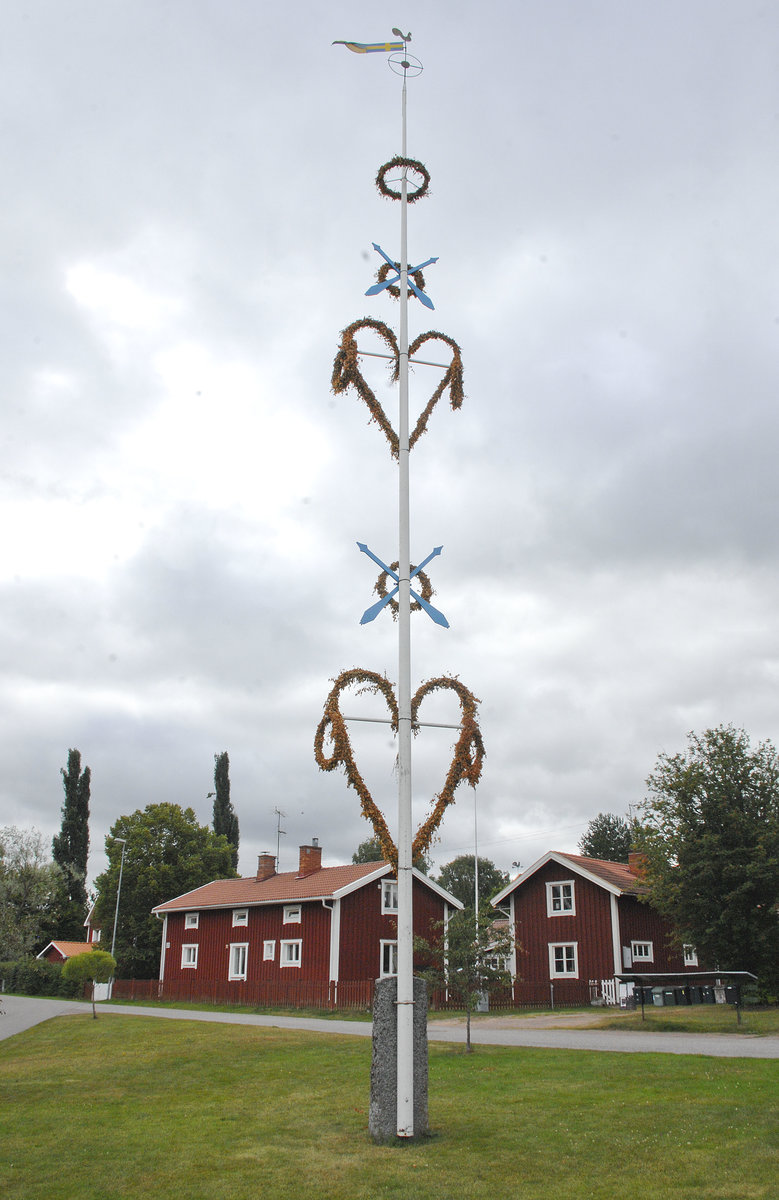 Ein Mittsommerbaum (Maistange) in Yttermo sdlich von Leksand (Dalarna/Schweden). Am Mittsommerabend wird hier ein geschmckter Baumstamm aufgerichtet, der Mittsommerstange (midsommarstng) oder Maistange (majstng) genannt wird. Maj hat hier nichts mit dem Monat Mai zu tun, sondern geht auf das altertmliche Verb Mama (mit Blumen schmcken) zurck. 
Aufnahme: 25. Juli 2017.