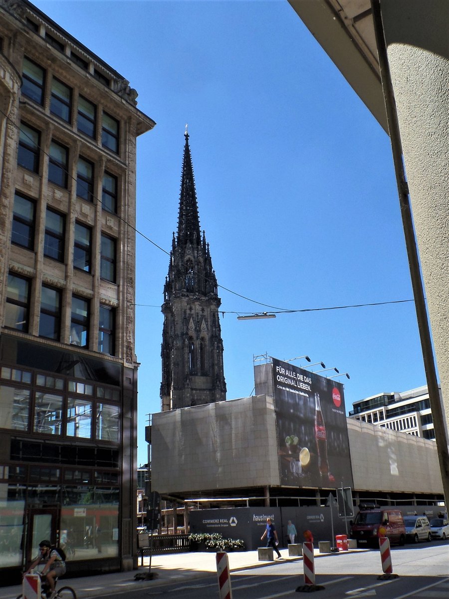 Ein seltener Durchblick in Hamburg am 2.7.2018: Blick von der Strae „Groer Burstah“ durch den „Kleinen Burstah“ auf das Mahnmal St. Nikolai. Diesen Blick wird man nur kurze Zeit haben, da das Gebude der Allianzversicherung (die Ruine mit der Coca Cola Werbung) gerade abgerissen und anschlieend durch ein neues Gebude ersetzt wird  /