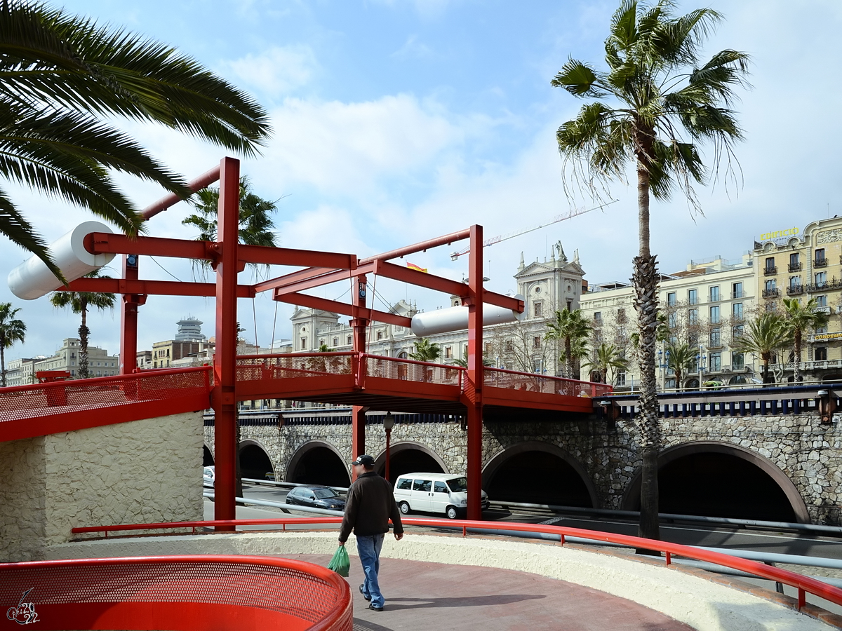 Eine rote Fugngerbrcke im Bereich des alten Stadthafens von Barcelona. (Februar 2012)