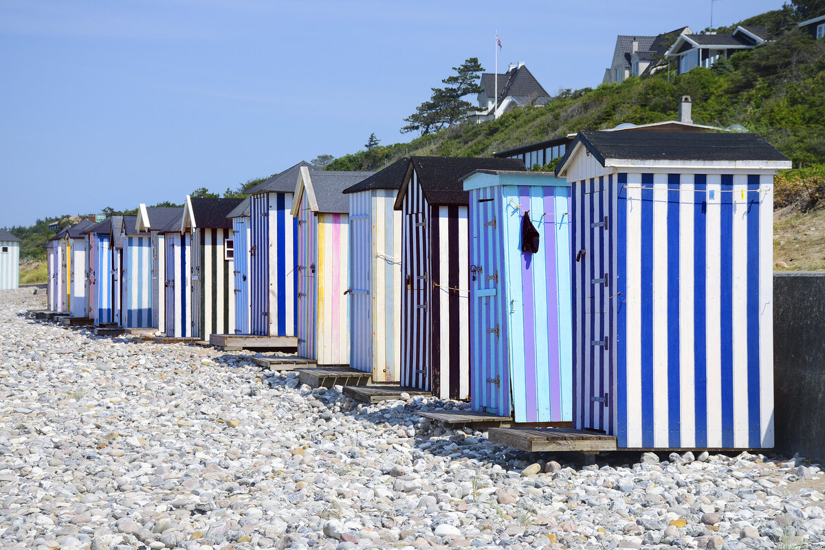 Farbenfrohe Badehuser am Strand vor Rgeleje auf Nordseeland. Aufnahme: 22. Juni 2023.