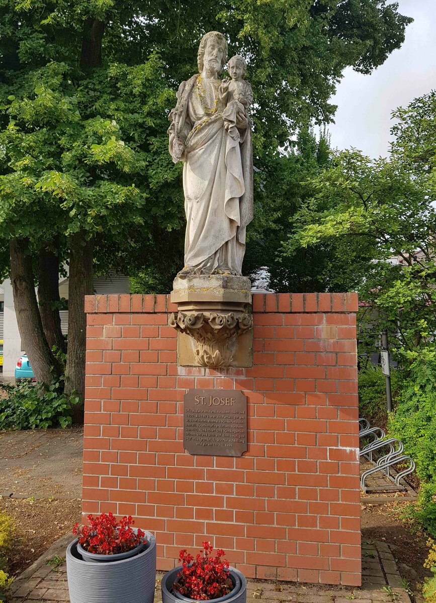 Figur des Hl. Josef in Hnfeld. Die Skulptur war bis 1973 die Portalfigur vom St. Josefsheim, einer ehemaligen Kinderbewahranstalt, Knabenkonvikt und Kindergarten. 1973 musste das imposante Backsteingebude einem Hallenbadbau weichen. Zur Erinnerung an das St. Josefsheim wurde die ehemalige Portalfigur im Jahr 2005 auf diesem Backsteinsockel wieder in die ffentlichkeit gerckt.