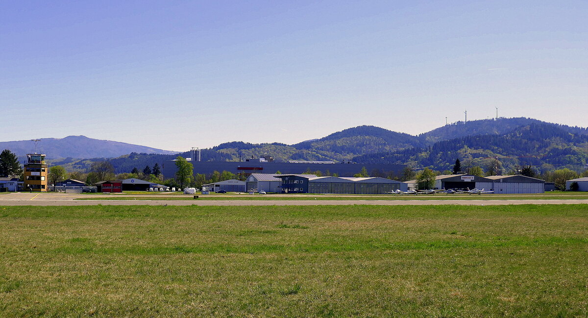 Freiburg, Blick ber die Start-und Landebahn am Flugplatz, dahinter die Hangars und links der gelbe Tower, April 2022