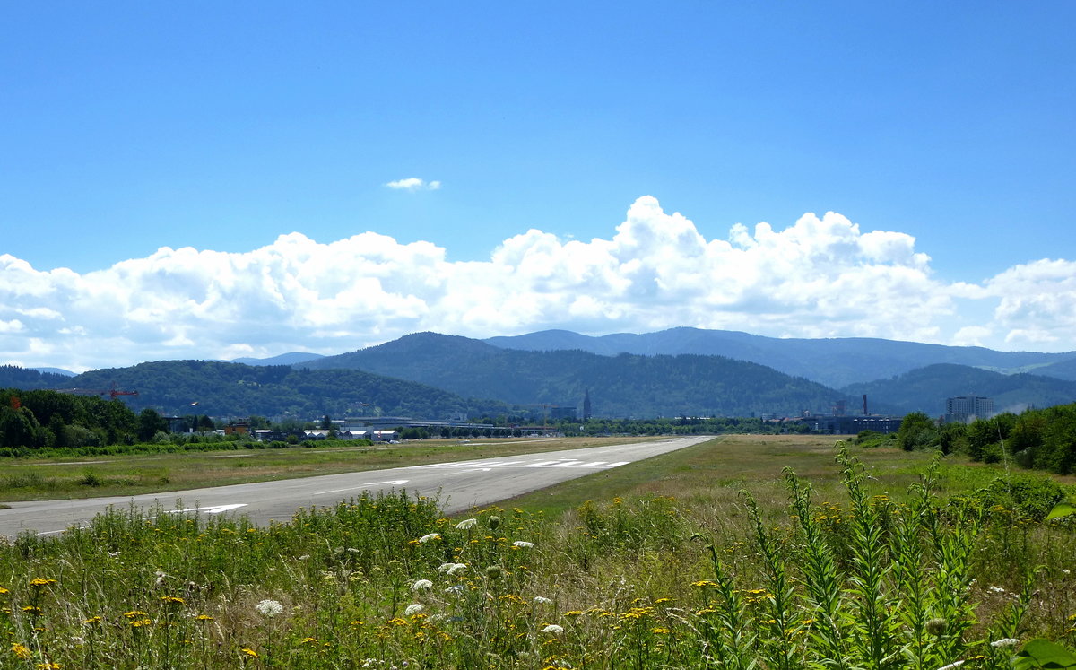 Freiburg, der Flugplatz gehrt zu den ltesten in Deutschland, Blick auf die in Nordwest-Sdost verlaufende 1400m lange Start-und Landebahn, die Stadt und der Schwarzwald im Hintergrund, Juli 2017