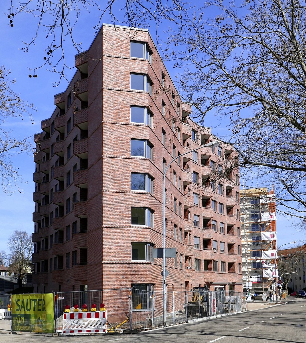 Freiburg-Herdern, das Rennwegdreieck, ein 8-geschossiger Wohnbau mit Geschften im Erdgescho auf dreieckigem Grundri, der Neubau mit Klinkerfassade stammt von einem Basler Architektenbro, Mrz 2021