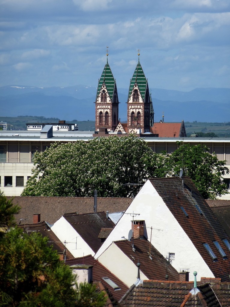 Freiburg, Teleblick von der Dachterrasse eines Restaurants in westliche Richtung mit den Trmen der Herz-Jesu-Kirche im Stadtteil Sthlinger, am Horizont die Vogesen, Mai 2015 