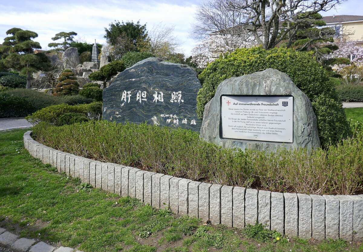 Freiburg-West, Gedenkstein am Eingang zum Japanischen Garten, rechts die deutsche bersetzung, der Garten am Seeparkgelnde wurde 1990 erffnet zur Stadtepartnerschaft Freiburg-Matsuyama, Mrz 2023