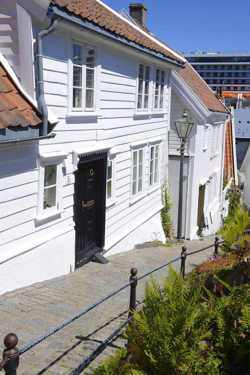 Gasse in der Stavanger Altstadt. Die meisten der Huser in Gamle Stavanger sind wei gestrichen. Stavanger wurde mehrfach ausgezeichnet, weil die Altstadt so gut bewahrt wurde. 
Aufnahme: 2. Juli 2018.