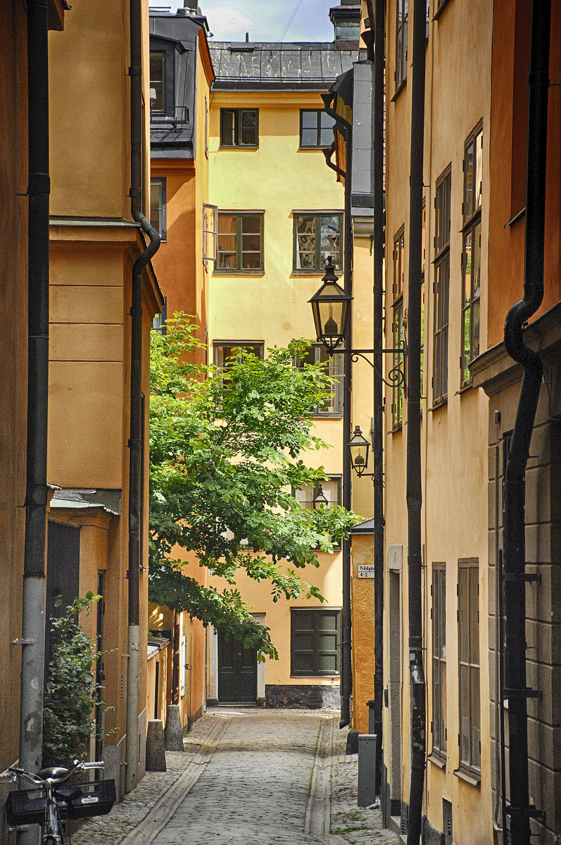 Gasse in der Stockholmer Altstadt (Gamla Stan). Viele Touristen verbinden mit der Altstadt die engen Gassen, die vielen in Erdfarben gestrichenen alten Giebelhuser und die kleinen Pltze mit ihren Cafs, Restaurants, Galerien und Kunsthandwerksgeschften.
Aufnahme: 25. Juli 2017.