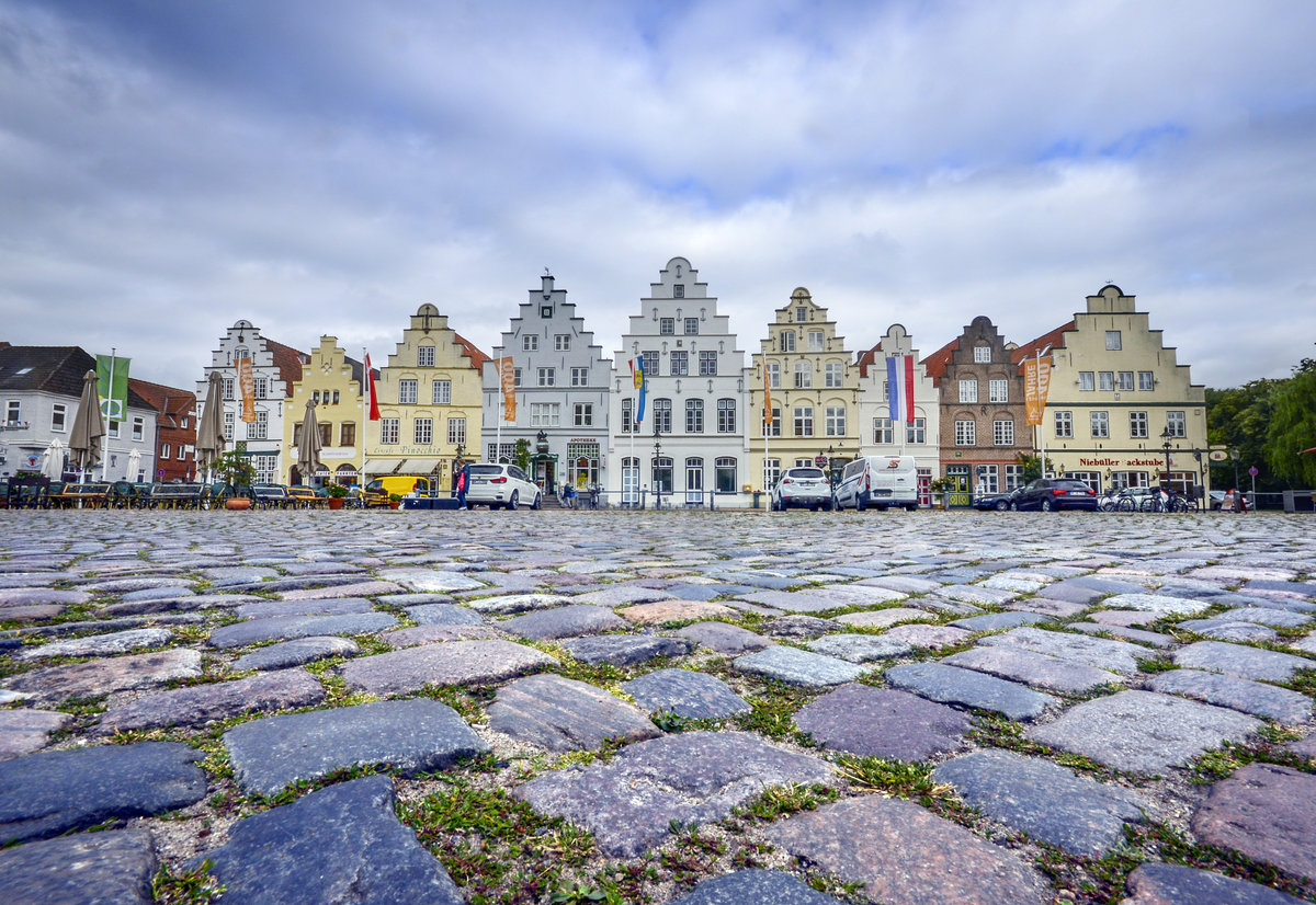 Giebelhuser am Markt in Friedrichstadt. An der Westseite des Marktplatzes befinden sich noch neun Treppengiebel aus Backstein, die in der Grnderzeit der Stadt entstanden sind und heute das grte zusammenhngende Ensemble von Bauten aus der Grndungsphase der Stadt bilden. Wie die anderen Huser aus der Grndungsepoche auch, sind diese den hollndischen Vorbildern gem hoch und schmal. Aufnahme: 9. Juli 2019.