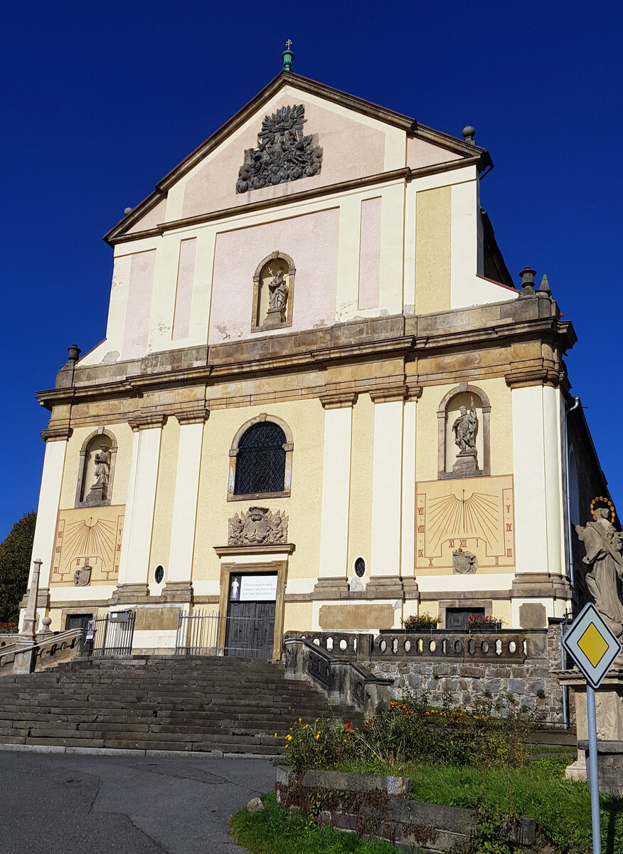 Giebelseite der Kirche des heiligen Nikolaus, Mikulasovice (Nixdorf im Schluckenauer Zipfel); auffällig sind zwei große Sonnenuhren; 17.10.2022
