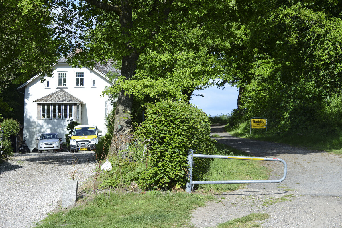 Grenzbergang Haraldsdalvej in Padborg (deutsch Pattburg). Das Haus auf der linken Seite befindet sich auf dnischem Gebiet. Der Weg rechts befindet sich auf deutschem Gebiet. Die Grenze zwischen Dnemark und Deutschland verluft genau rechts von der Buchenhecke in der Bildmitte. Aufnahme: 28. Mai 2023.