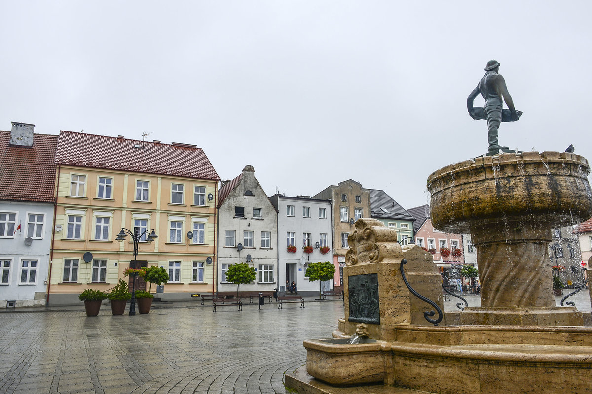 Huser am Rathausplatz in Darłowo (Rgenwalde) in Hinterpommern. Rechts im Bild ist der Hansabrunnen zu sehen. Aufnahme: 22. August 2020.