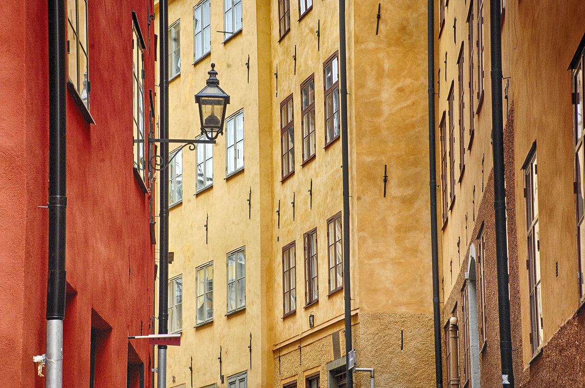 Huser an einer Altstadtgasse in Gamla Stan von Stockholm. In den Gebuden findet man hufig mittelalterliche Kellergewlbe, Kalkmalereien des 16. Jahrhunderts, reich verzierte Deckenbalken des 17. Jahrhunderts, hochklassige Innenausstattungen im Rokokostil oder berbordende Dekorationen des 19. Jahrhunderts.
Aufnahme: 25. Juli 2017.