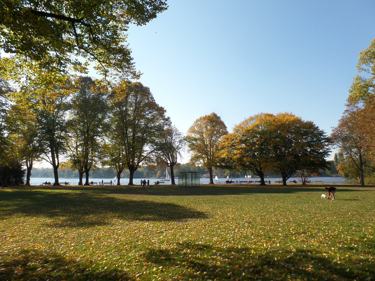 Hamburg am 11.10.2018: Parkanlage „Uhlenhorster Fhrhaus“ an der Auenalster mit dem mittig zu sehenden „Glaskasten“ „Double Triangular Pavilion for Hamburg“ des Knstlers Dan Graham /