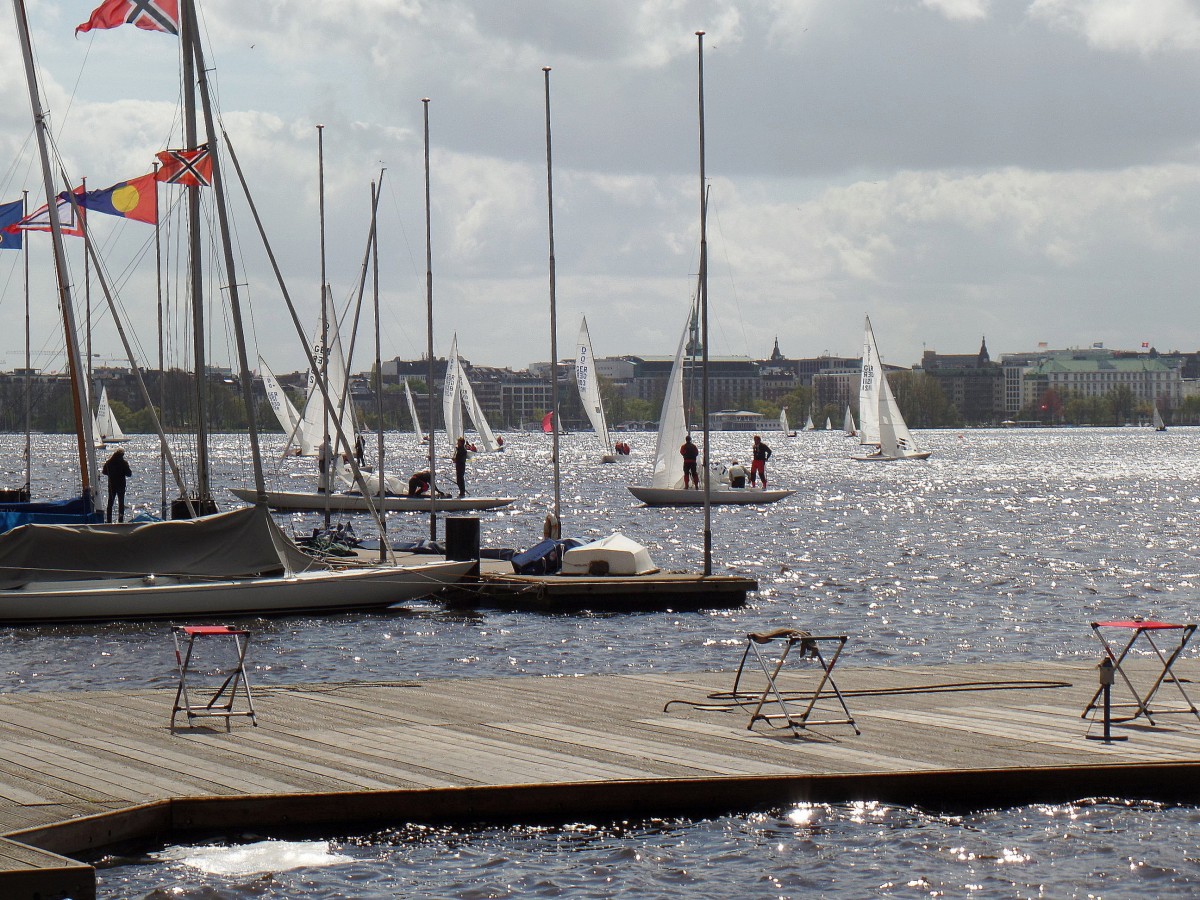 Hamburg am 13.4.2014: bei gleiendem Sonnenlicht ein Blick ber die Auenalster vom Uhlenhorster Fhrhaus nach St. Georg mit den von einer Regatta zurckkehrenden Drachen.