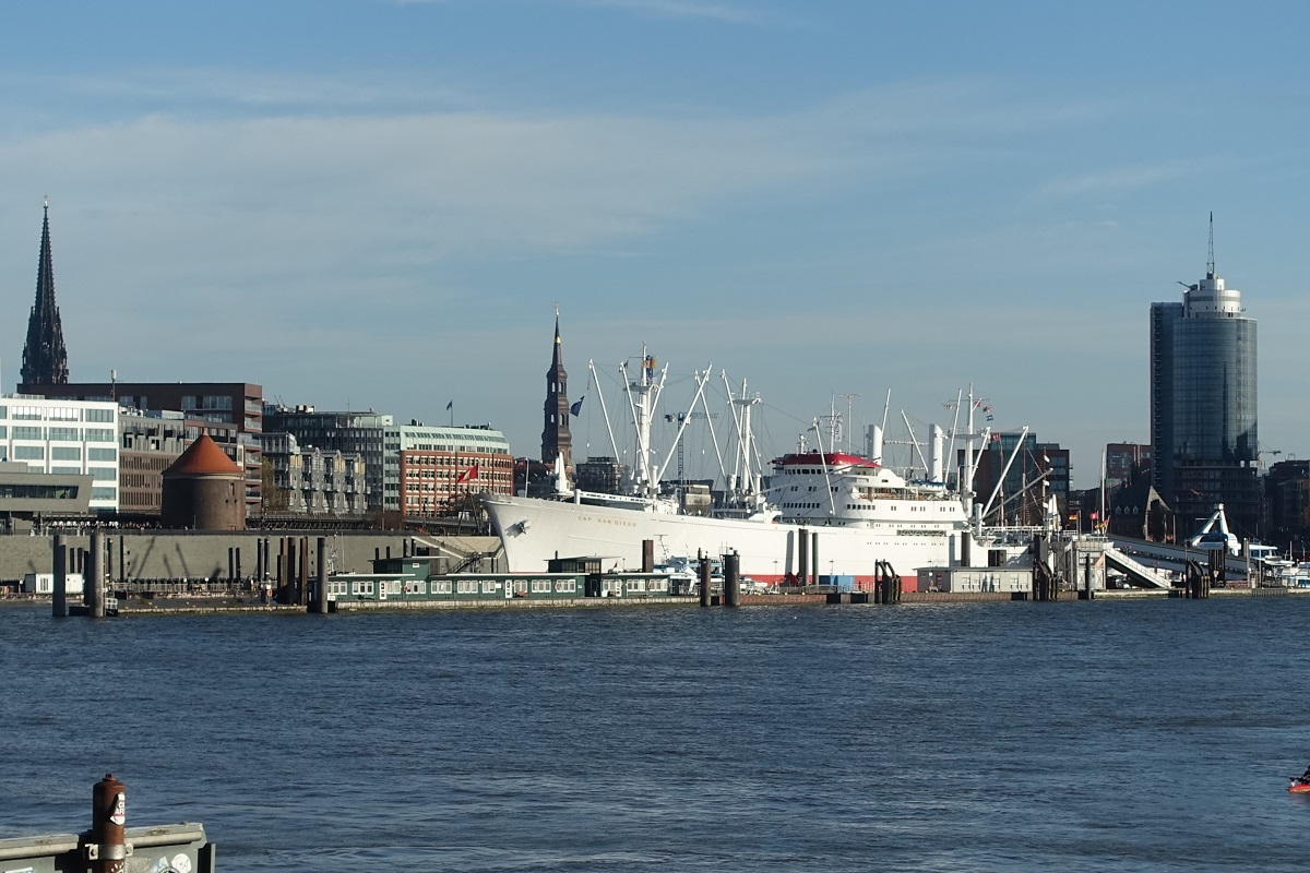 Hamburg am 15.11.2020: ein Teil der Hamburg Skyline von der Sdseite der Elbe (Steinwerder) gesehen – links der Turm des Mahnmals St. Nikolai, mittig die Katharinenkirche in der Neustadt, rechts der Beginn der Hafencity, im Vordergrund die berseebrcke mit dem Museumsschiff CAP SAN DIEGO /