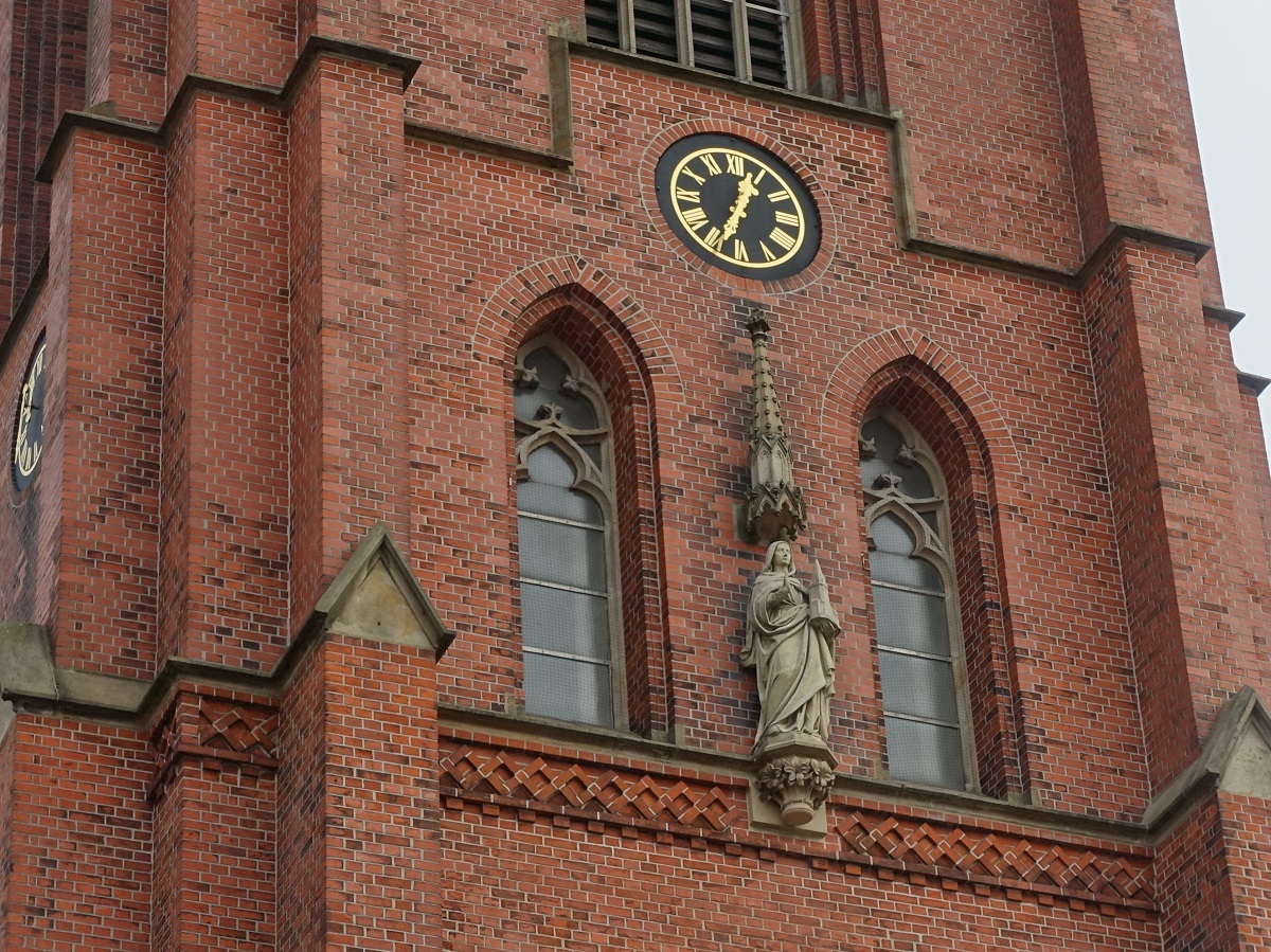 Hamburg am 20.3.2021: Turmuhr und Figur der Schutzpatronin Sophia von Rom am Portal der unter Denkmalschutz stehenden 1900 erffneten rmisch-katholischen Pfarrkirche St. Sophien / die Kirche steht im Stadtteil Barmbek-Sd und ist der Sophia von Rom geweiht, sie gilt als Schutzpatronin gegen spte Frste, bekannt als „Kalte Sophie“ whrend der Eisheiligen /